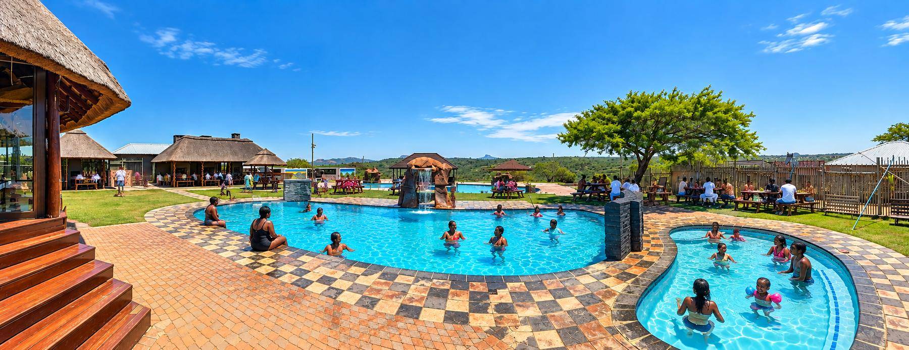 A full summer day at the pools, with guests swimming and picnicking