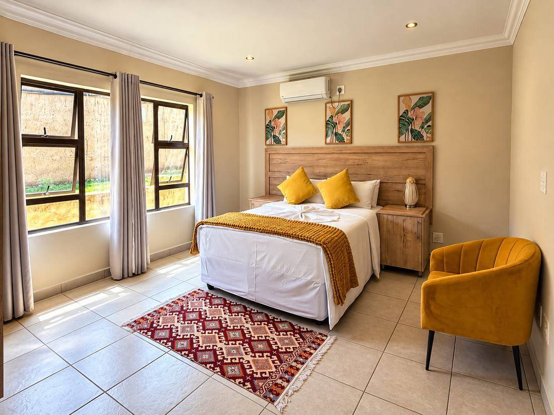 Bedroom in a 2-bedroom chalet with a double bed and mustard armchair