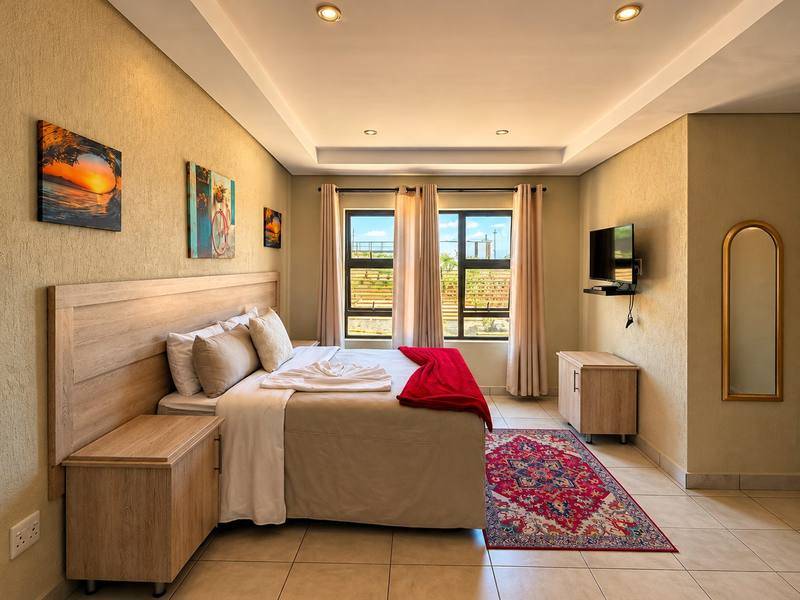 Lion double room with a double bed, red throw and patterned rug