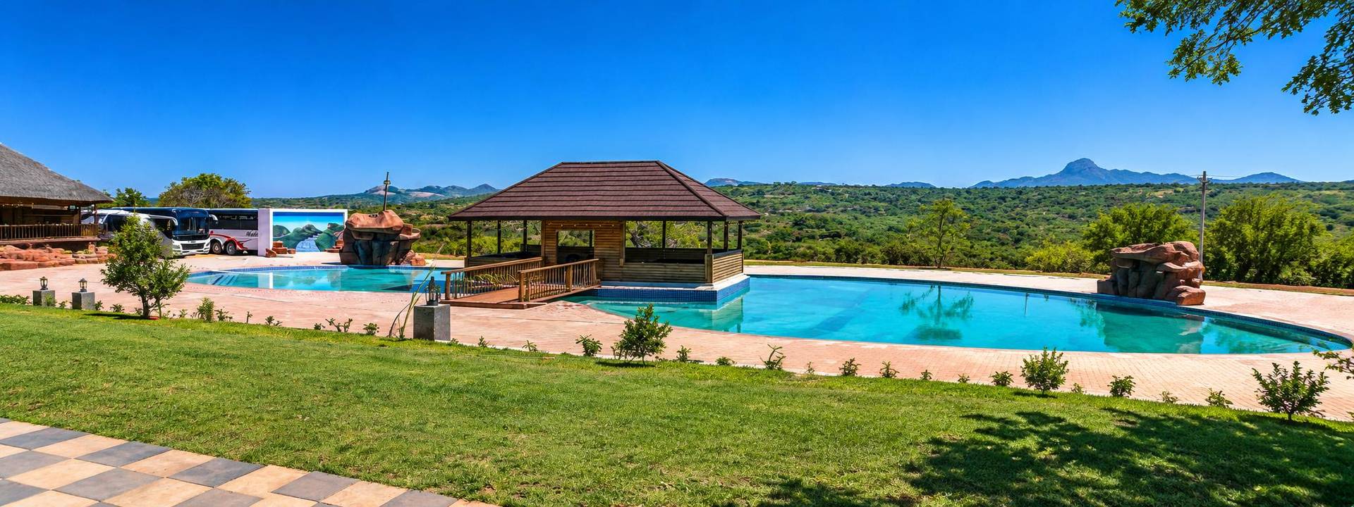 The new big pool with a covered mini lapa on a wooden deck, looking out over the bushveld hills